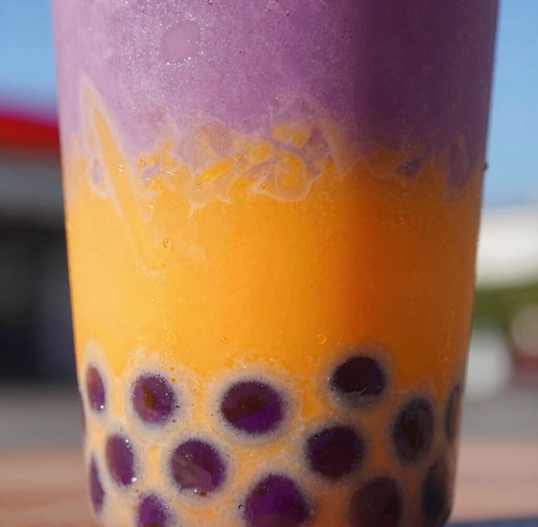 Close-up of a vibrant purple and orange layered bubble tea in a clear cup, textured tapioca pearls visible at the bottom, bright natural daylight with neon accents, 35mm lens