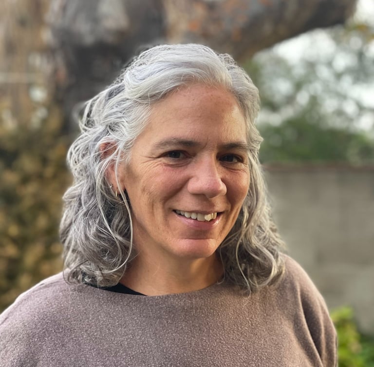 Woman with grey hair and brown sweater