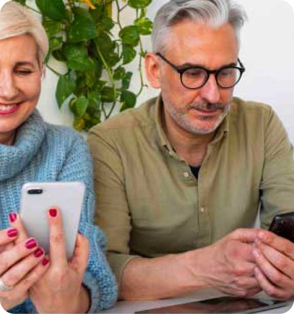 hombre y mujer sonriendo mirando su móvil
