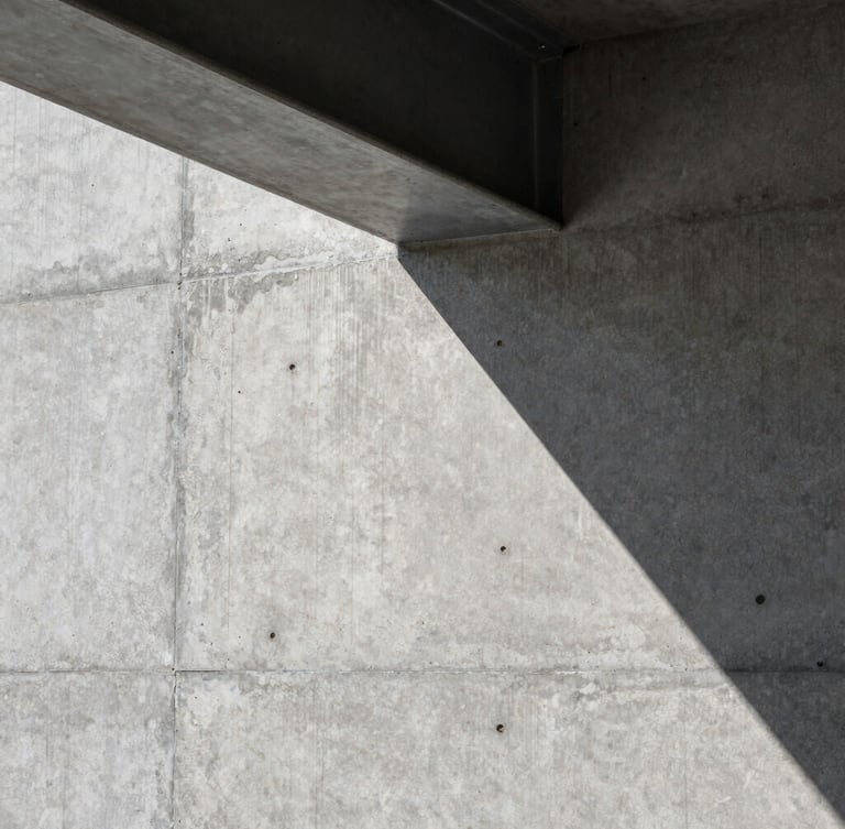 Close-up of a raw, perfectly poured concrete wall meeting a clean steel beam, sharp architectural lighting with deep shadows, precise textures.