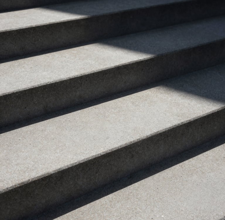 Macro close-up of sharp geometric concrete steps under harsh daylight, casting deep architectural shadows