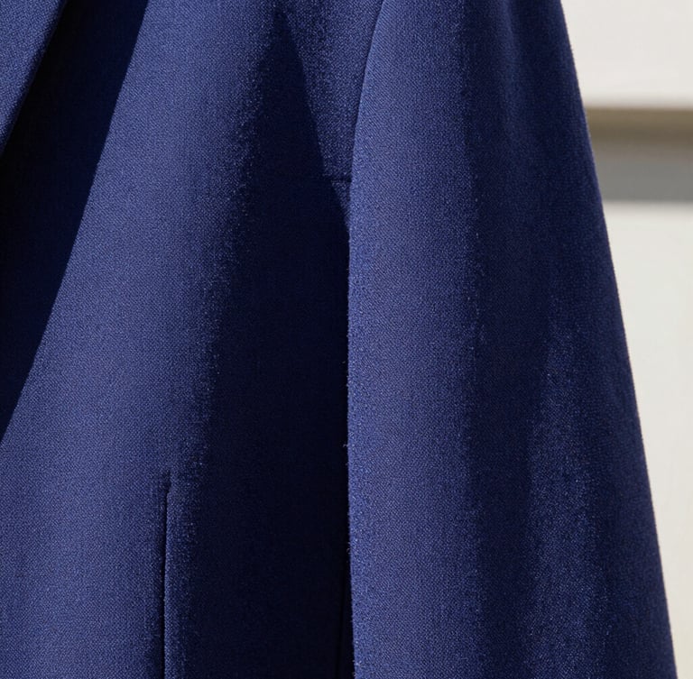 Extreme close-up macro shot of heavy-knit periwinkle cotton fabric texture, sharp direct sunlight casting deep geometric shadows on technical seams, high-fashion editorial feel, 35mm lens.