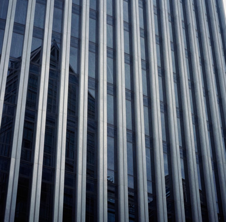 Abstract architectural lines of a modern corporate high-rise building reflecting cool daylight, sharp angles, deep navy and silver tones, 35mm