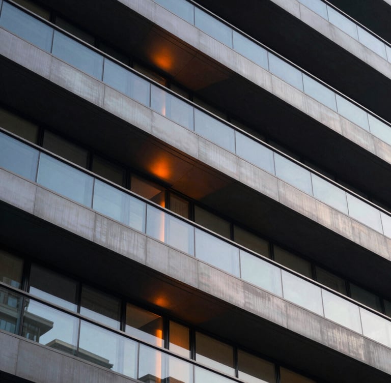 Extreme close-up of structured architectural lines in dark steel and glass, warm orange light leak reflecting on clean metallic surface, sophisticated corporate photography, 35mm lens