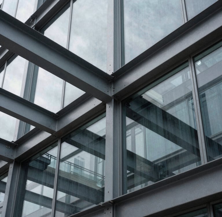 Tight abstract architectural crop of structural steel beams and glass panels, sharp overcast shadows, desaturated slate tones, 35mm