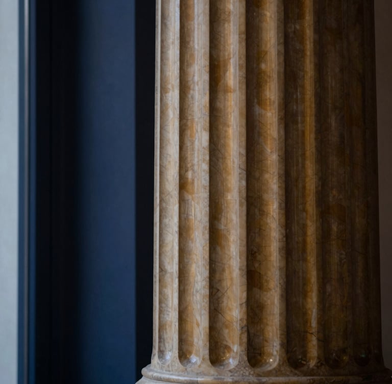Close-up of a classical architectural column, made of warm-toned marble, with soft, directional window light highlighting its texture, deep navy and warm brass tones, shallow depth of field, 50mm