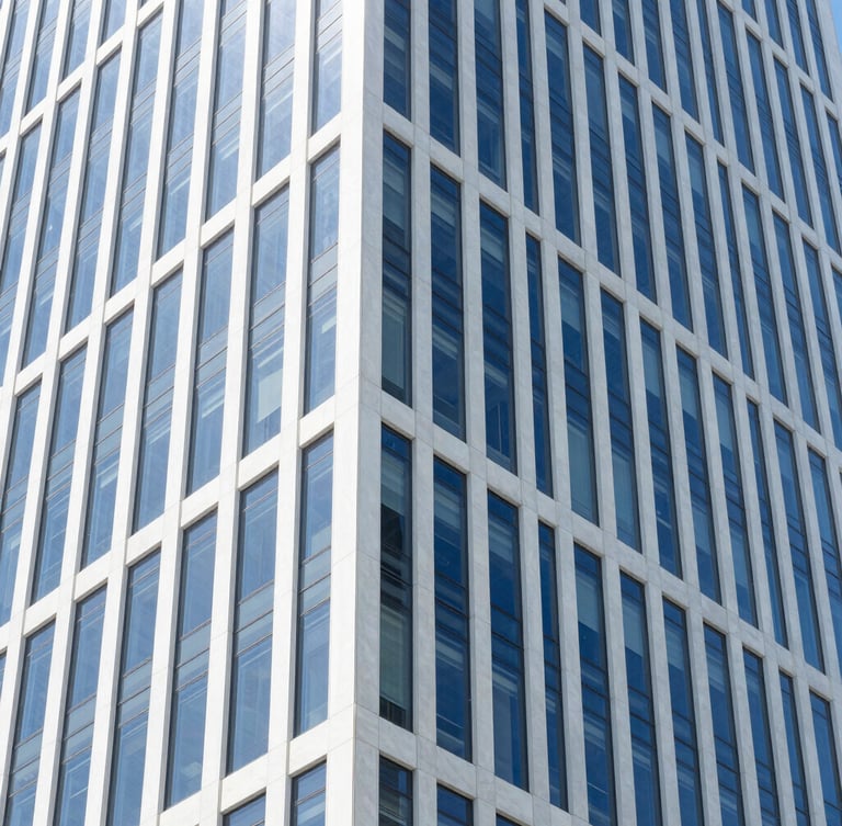Crisp architectural photo of a modern high-rise office interior, clean glass walls, bright natural daylight, deep blue and white tones, sharp focus