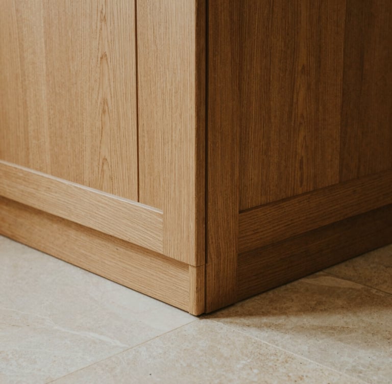 Close-up of grain-matched oak paneling meeting a honed limestone floor, perfect joinery, warm architectural photography, natural side-lighting