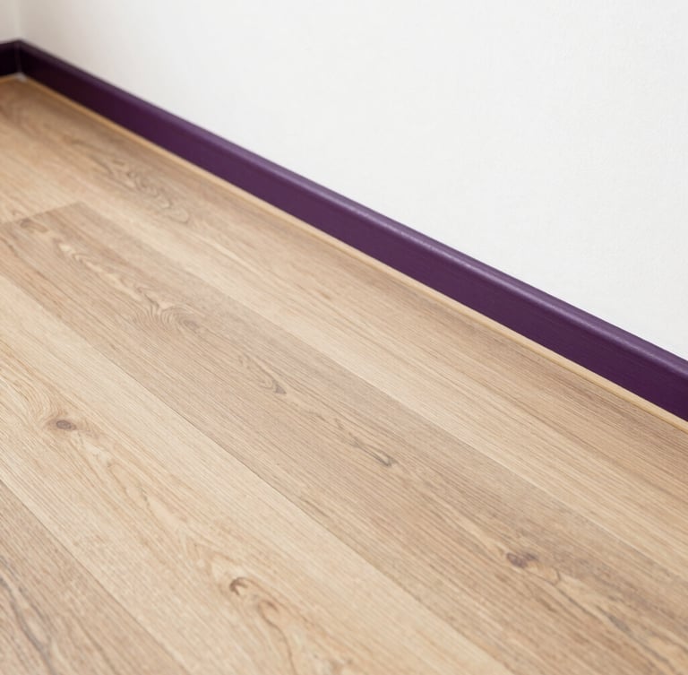 Detail shot of perfectly aligned laminate wood flooring meeting a clean white wall, warm natural light, architectural precision