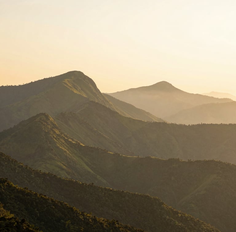 Panoramic view of misty green mountains of Minas Gerais at sunrise, soft golden light on the peaks