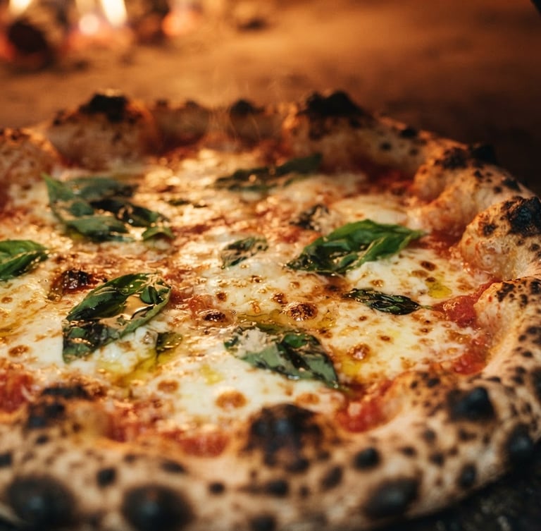 Extreme close-up of a perfectly blistered Neapolitan Margherita pizza, bubbling cheese, fresh basil leaves, and leopard-spotted crust, lit by warm firelight, shallow depth of field, 35mm.
