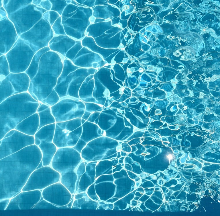 Top-down overhead shot of a pristine, crystal-clear swimming pool water surface under direct, bright high-noon sunlight, sharp clean shadows on pool tiles, highly detailed water texture.