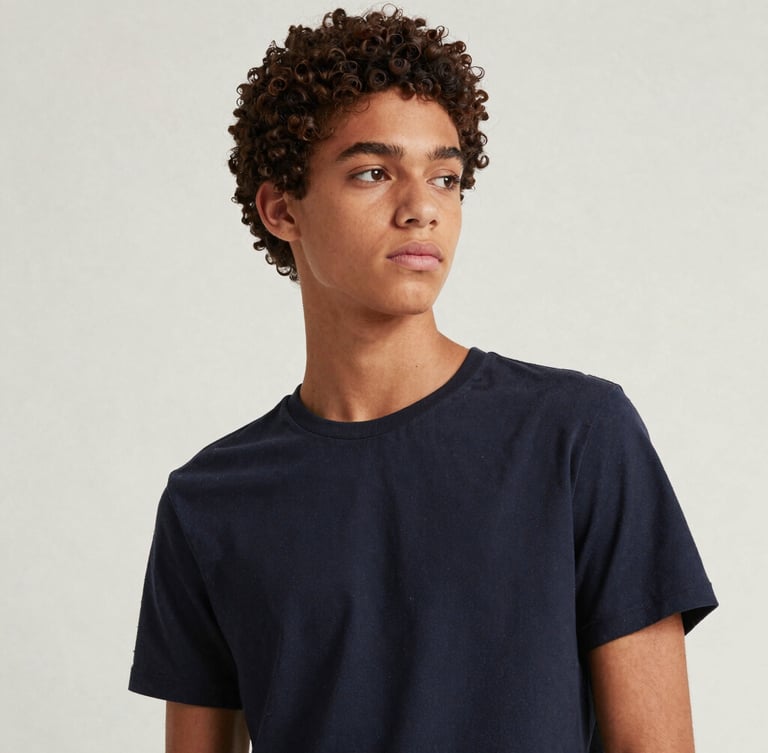Editorial fashion portrait of a stylish Brazilian teenager looking thoughtful, clean minimalist background, soft natural daylight, rich muted tones, high-end magazine style.