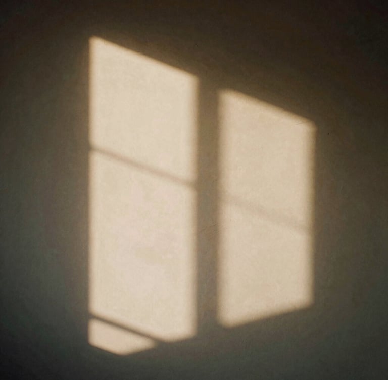 Minimalist architectural shadows on a warm plaster wall, sharp directional sunlight, contemplative quiet atmosphere, 35mm film.