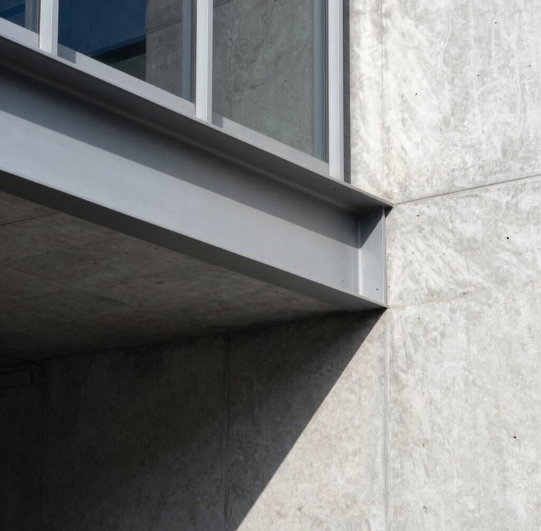 Close-up, high-contrast architectural detail of a structural steel beam connecting to a concrete wall, sharp natural daylight creating deep shadows, minimalist aesthetic, 35mm lens.