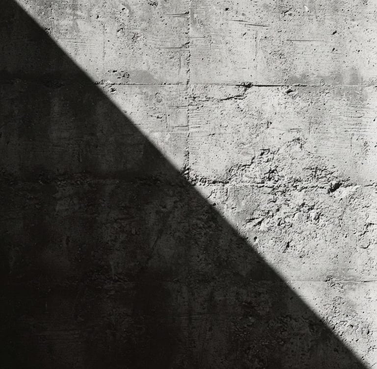 Extreme close-up of a sharp shadow cast across a textured concrete wall, minimalist architectural photography, high-contrast hard sunlight, monochrome desaturated tones, 35mm