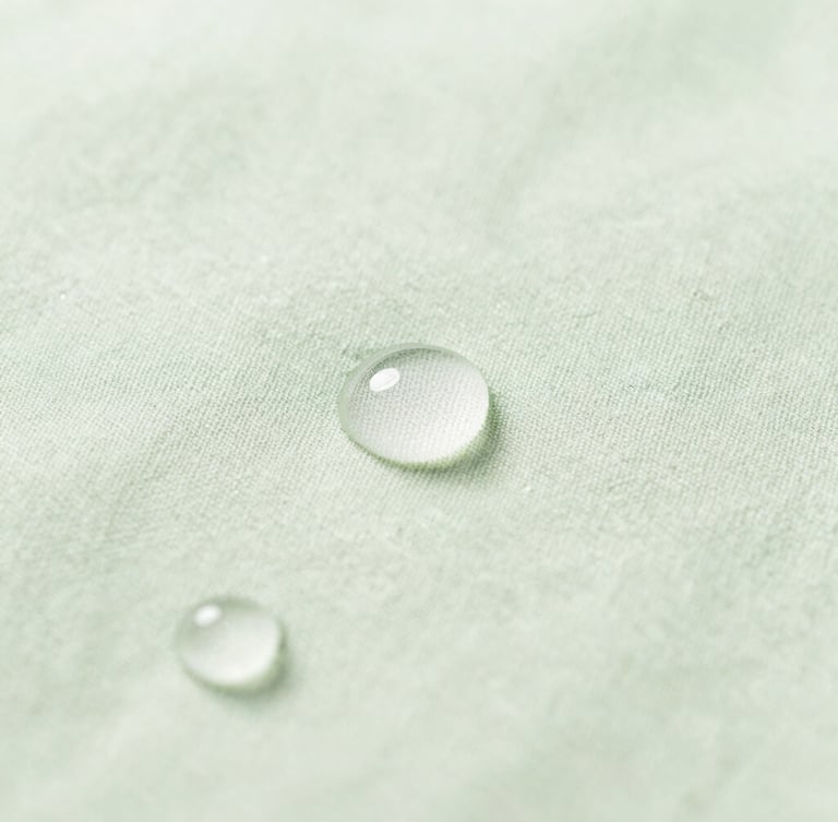 Macro shot of pure water droplets on organic cotton fabric, soft natural morning light, clean sage green tones, portrait aspect