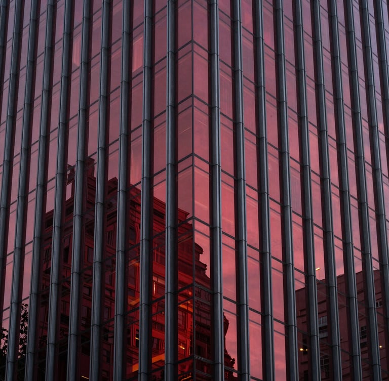 Sleek modern corporate skyscraper facade, dramatic architectural lighting, deep crimson reflections on glass, sharp focus, high-end editorial style