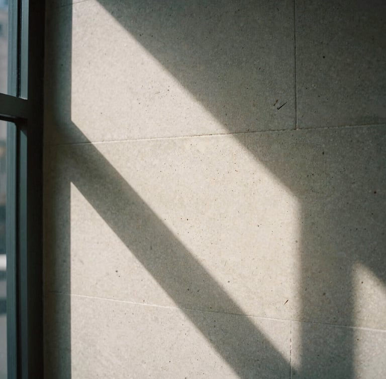 Macro close-up of natural light casting deep graphic shadows across a textured travertine stone wall in a quiet Manhattan office, sober editorial photography, 35mm film