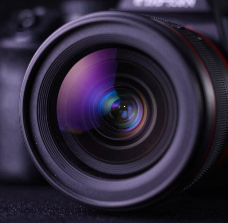 Extreme close-up of a professional camera lens in a dark studio setting, reflecting deep purple and vibrant blue key lights, cinematic shallow depth of field, subtle dust particles catching the light