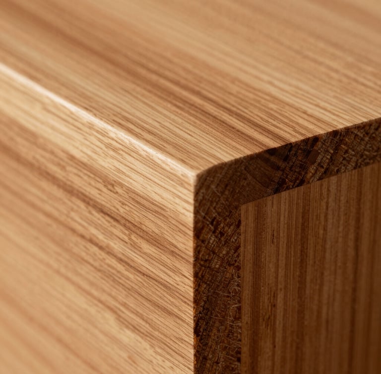Extreme close-up of custom hand-cut dovetail joinery in premium quarter-sawn elm, warm natural oil highlighting the deep amber grain