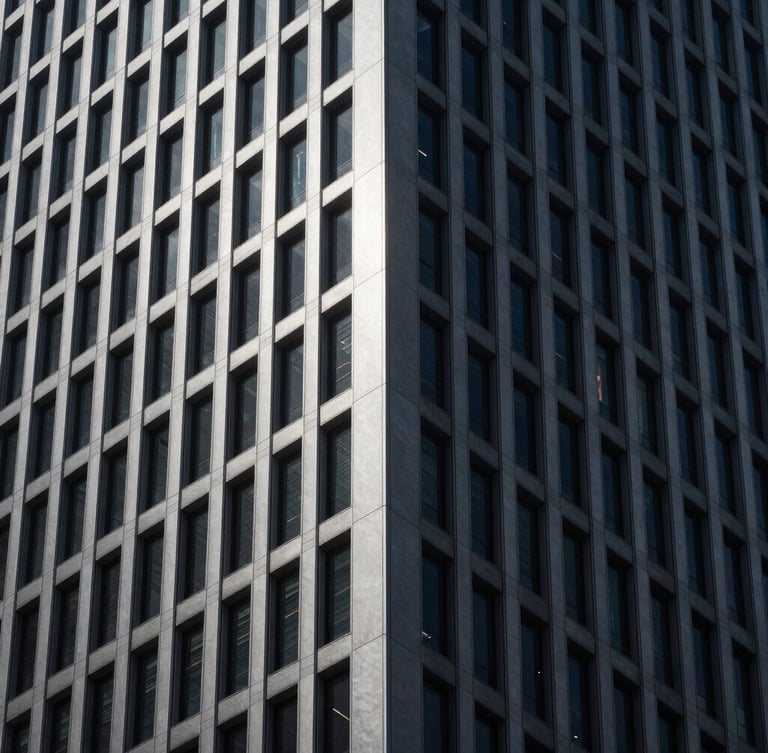 Sleek architectural photography of a monolithic corporate tower corner, dramatic low-key lighting, deep obsidian and cool silver tones, sharp focus, 35mm.