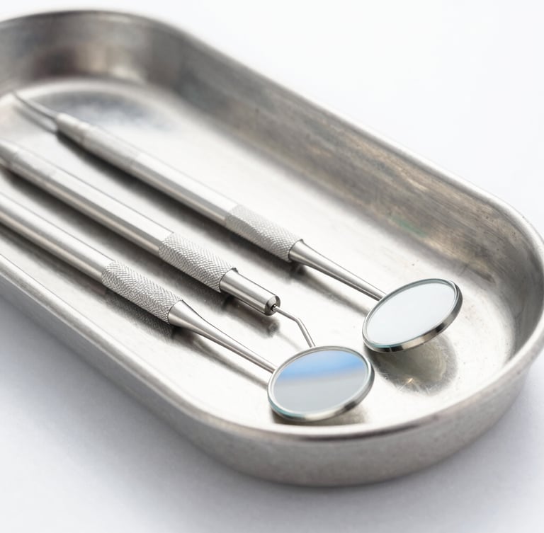 Macro shot of high-precision dental explorers and mirrors lying on a sterile light gray metal tray, bright high-key studio lighting, clinical white and blue tones, sharp focus