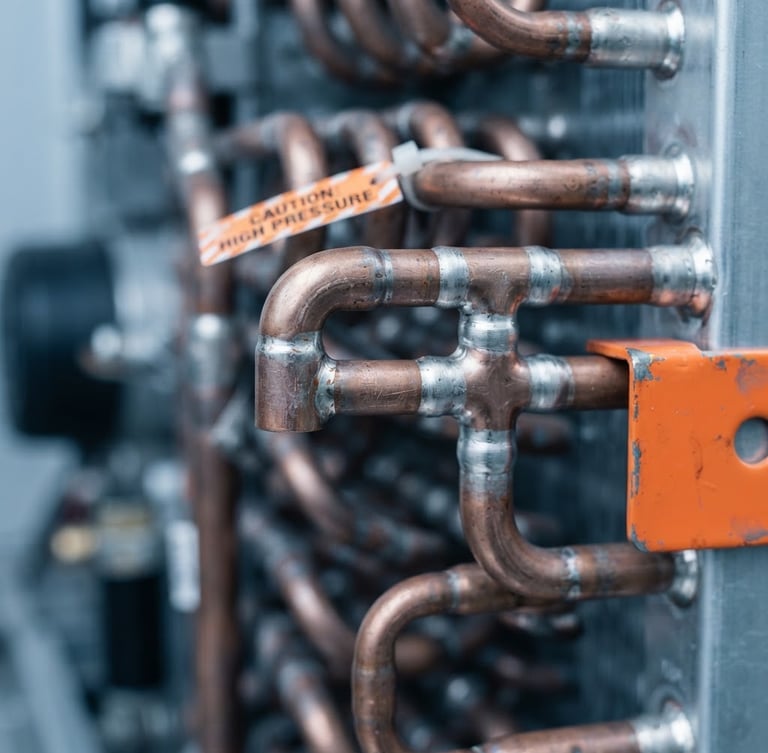 Macro photograph of a copper refrigeration coil with precise solder joints, cool metallic tones, sharp focus, 50mm lens