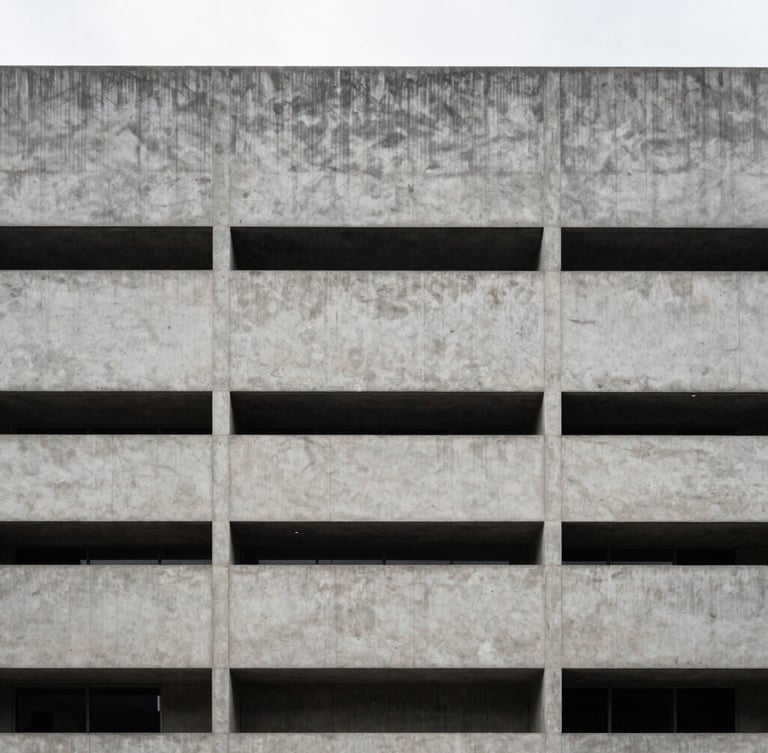 Sober architectural photography of a modern concrete building facade in Bogota under crisp overcast daylight, symmetrical composition, desaturated cool tones