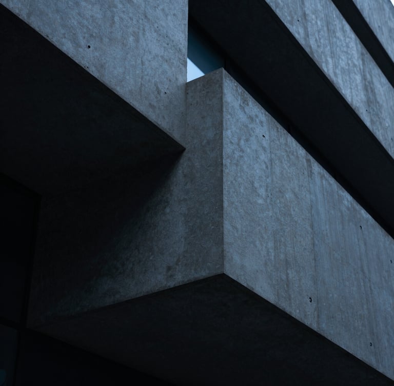Abstract architectural geometry representing structure, close-up of sharp concrete angles, cool low-key corporate lighting with subtle blue ambient glows, 35mm