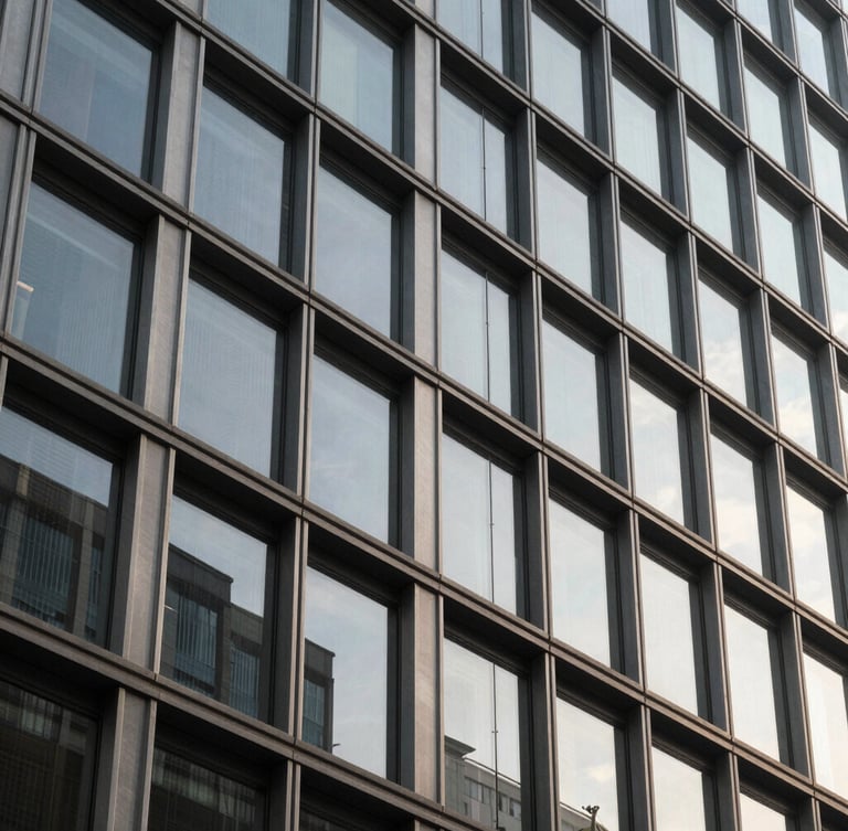 Detailed architectural close-up of a modern corporate building facade, sharp geometric lines of steel and glass, soft natural morning light with subtle shadows, professional and sober tone.