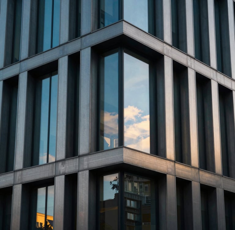 Dramatic close-up of a modern brushed steel and glass corporate facade in Budapest, sharp focus, cool blue tones with warm golden-hour window highlights, 35mm lens.
