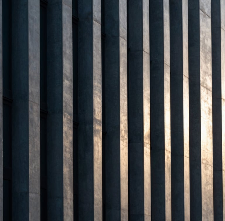 Abstract geometric pattern of light and shadow on a modern concrete facade, clean vertical lines, cool charcoal and silver tones, sharp focus