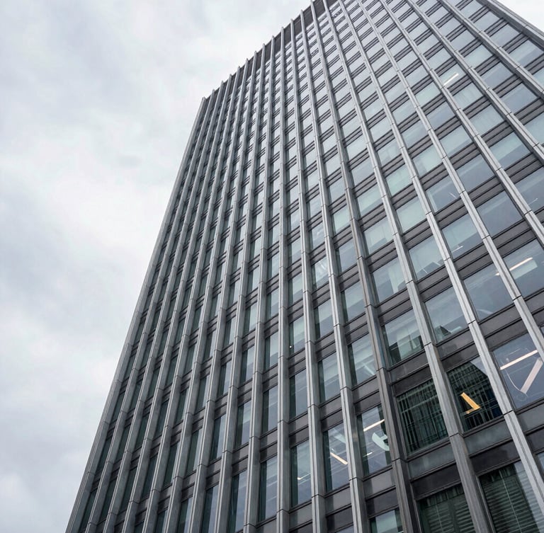 Wide architectural perspective of a modern steel and glass skyscraper facade in Wilmington, overcast daylight, sharp geometric lines, generous negative space on the left.