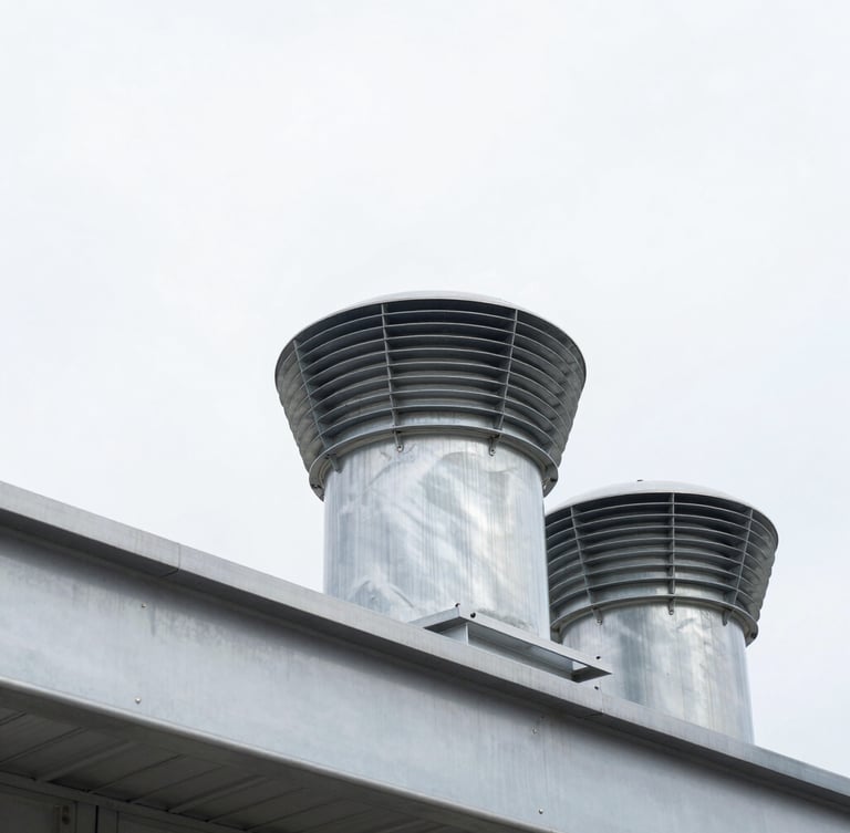 Low-angle architectural shot looking up at installed industrial roof vents against a crisp, bright overcast sky, sharp metal edges, 35mm