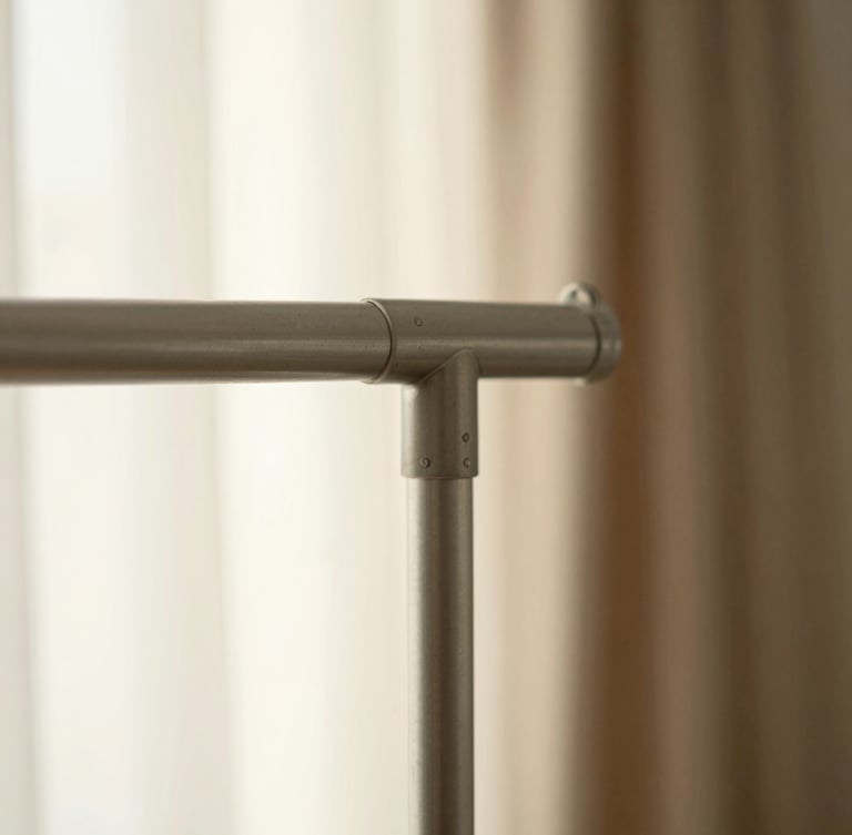 A close-up of a warm grey steel garment rack joint, highly detailed craftsmanship, soft morning light, shallow depth of field