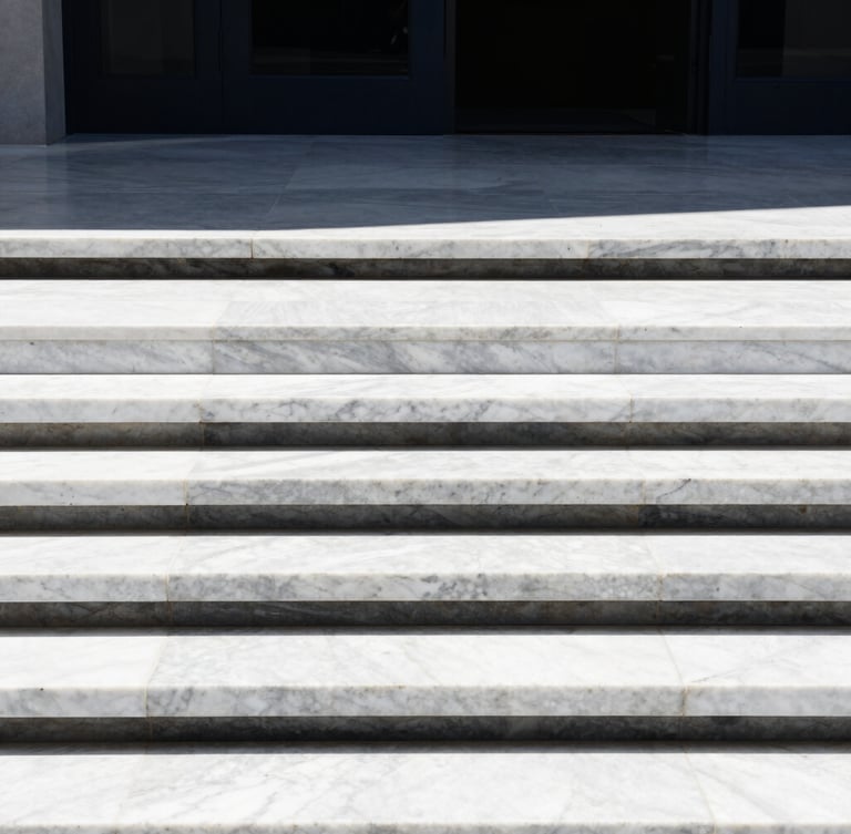 A minimalist architectural detail of premium white marble steps meeting a dark steel frame, crisp high-contrast sunlight, clean lines, editorial style.