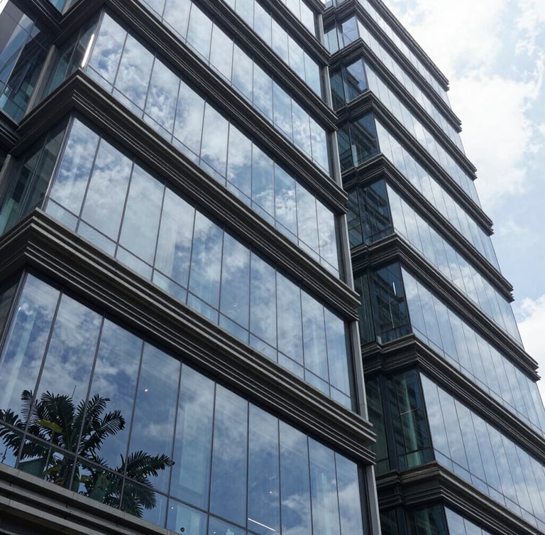High-contrast architectural shot of a modern Indian corporate headquarters in Bengaluru, sharp glass reflections, clean lines, daylight.