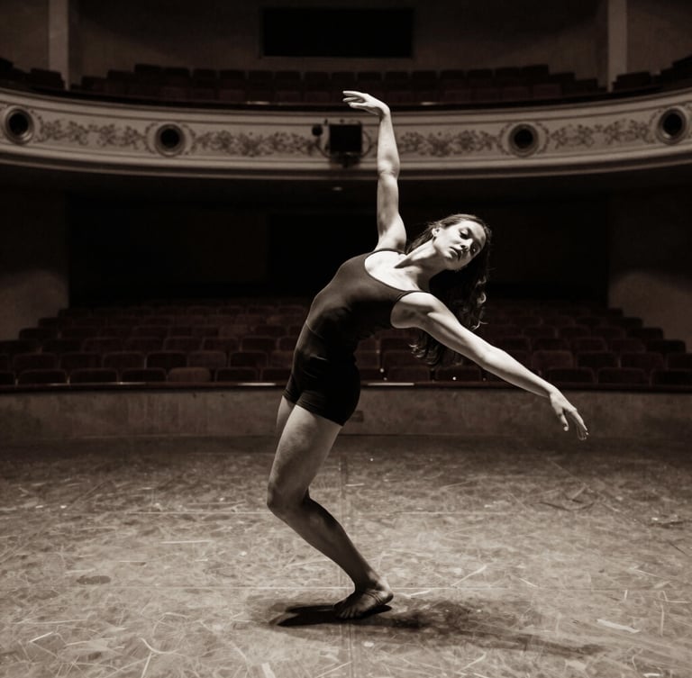 Elegant editorial dance photography of Victoria Holanda in a sharp physical extension, dramatic side-lit empty theater, high-contrast monochrome with warm clay undertones, 35mm