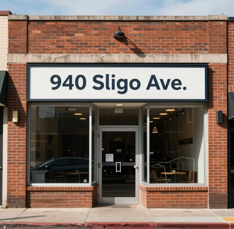 Straight-on eye-level architectural photograph of the clean brick storefront at 940 Sligo Ave under bright natural daylight, clear municipal signage, no people.