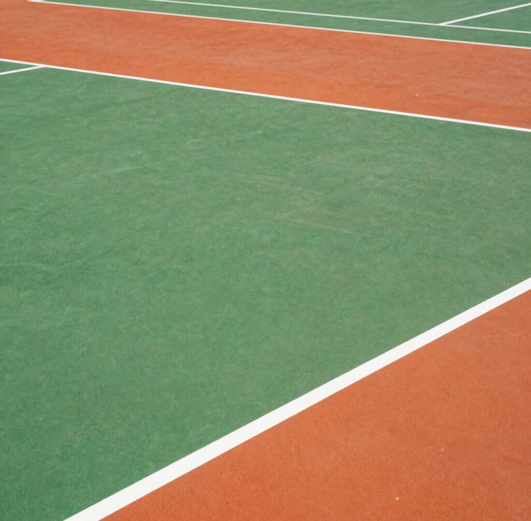 Tight top-down architectural grid of a freshly painted pickleball court, showing crisp white boundary lines on bright green and orange surfaces.