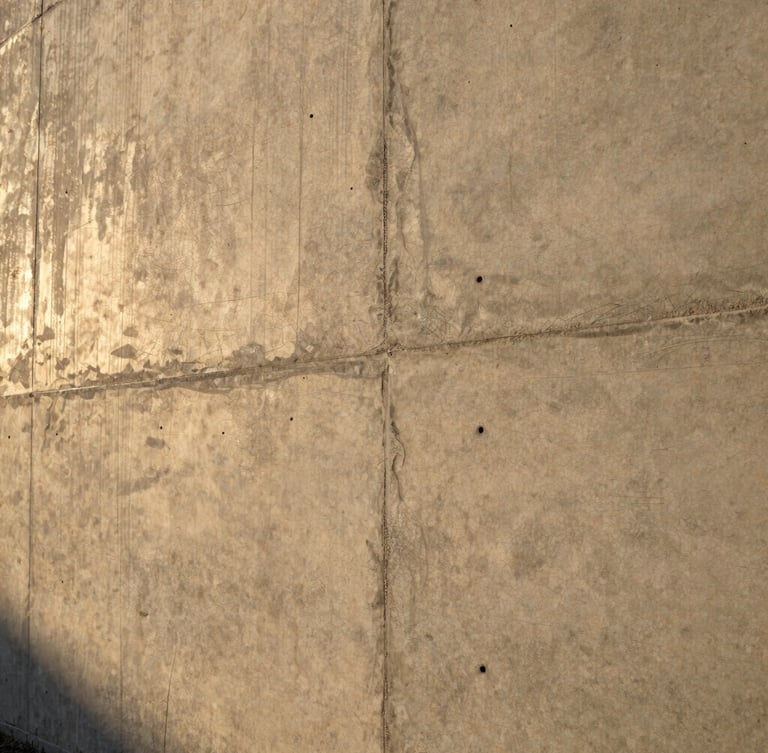 Close-up of a pristine, freshly poured architectural concrete wall, sharp focus, dramatic side lighting showing texture