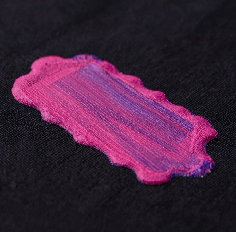 Extreme close-up of vibrant magenta ink layers drying on a heavy black cotton fabric, sharp studio lighting with subtle purple gel accents, macro detail, 50mm