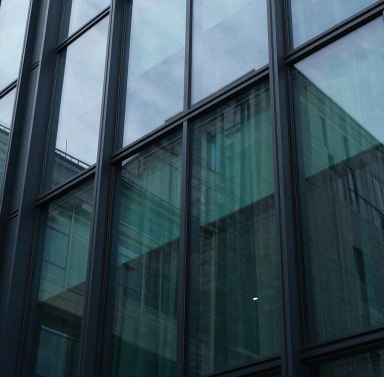Extreme macro close-up of a structured architectural glass facade reflecting cool daylight, sharp shadows, deep navy and emerald tones, 35mm