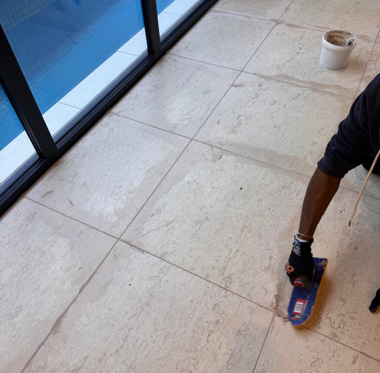 Re-grouting service removing old grout and restoring clean, strong tile joints.