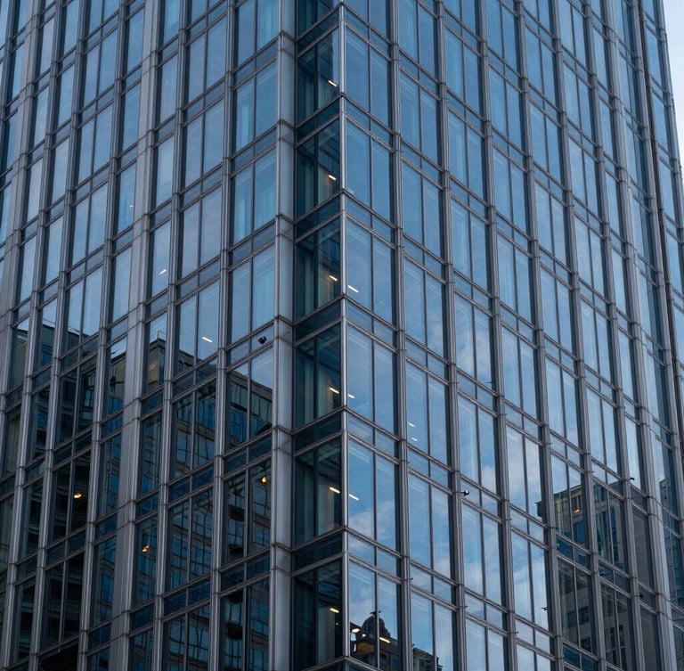 Symmetrical vertical shot of a modern glass and steel skyscraper corner, sharp blue hour reflections, kissing the left edge of the frame.