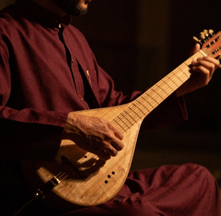 Dramatic close-up of a Sufi musician playing a traditional string instrument under low-key warm stage lighting, rich shadows, shallow depth of field