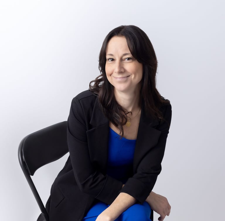 a woman wearing a blue outfit and black jacket sitting down