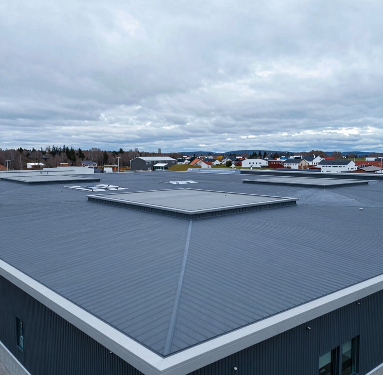 Extreme wide-angle drone shot of a massive modern flat roof with grey PVC membrane, clean geometric lines, overcast Nordic daylight, deep blue and slate tones, 35mm