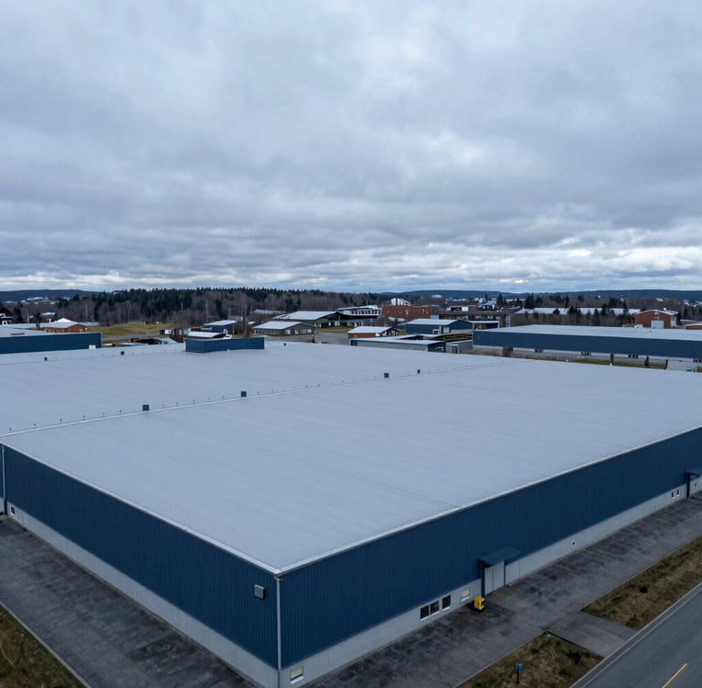 Architectural drone photography of a massive industrial flat roof with light grey PVC membrane, overcast Nordic daylight, deep blue and slate tones, crisp details, 35mm